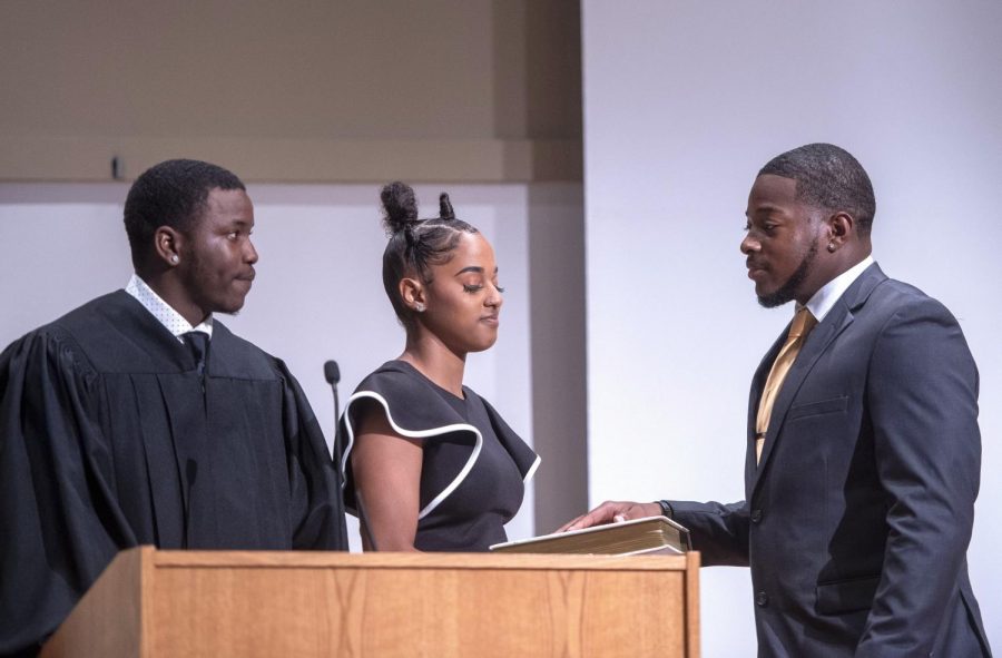 Associate Justice Freddie Hawkins and administers the Oath of Affirmation as Kleo Torres holds the Bible