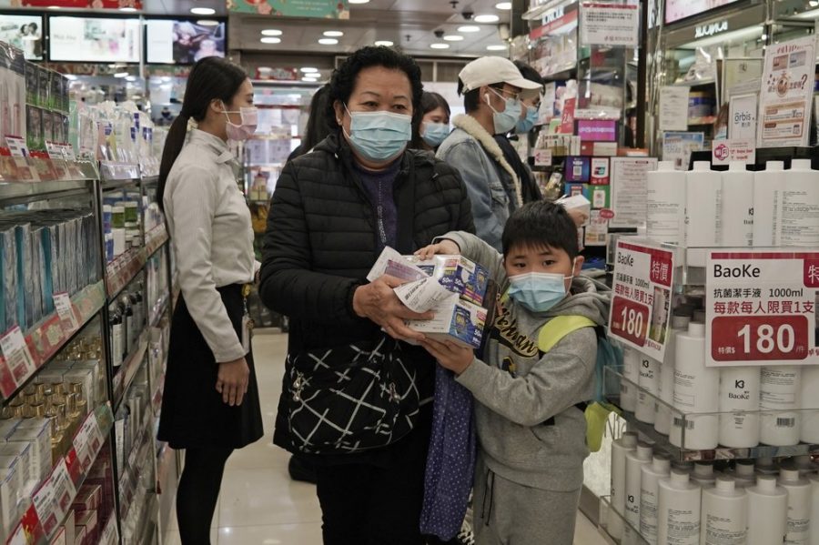 A woman a boy purchase face masks in Hong Kong, Saturday, Feb, 1, 2020. China’s death toll from a new virus has risen over 250 and a World Health Organization official says other governments need to prepare for“domestic outbreak control” if the disease spreads.