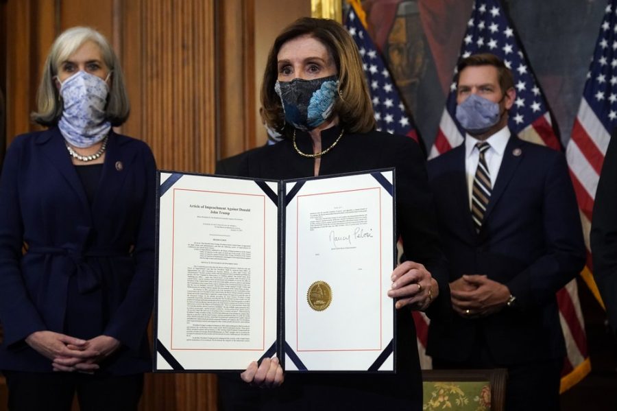 House Speaker Nancy Pelosi of Calif., displays the signed article of impeachment against President Donald Trump in an engrossment ceremony before transmission to the Senate for trial on Capitol Hill, in Washington, Wednesday, Jan. 13, 2021. (AP Photo/Alex Brandon)