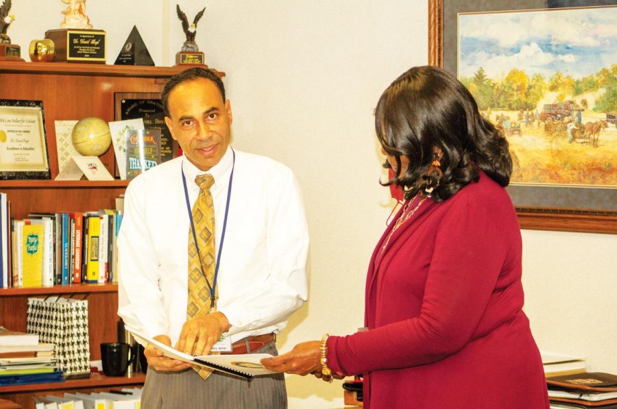 Deputy Superintendent of Education Daniel Boyd explains some new procedures to his administrative assistant.