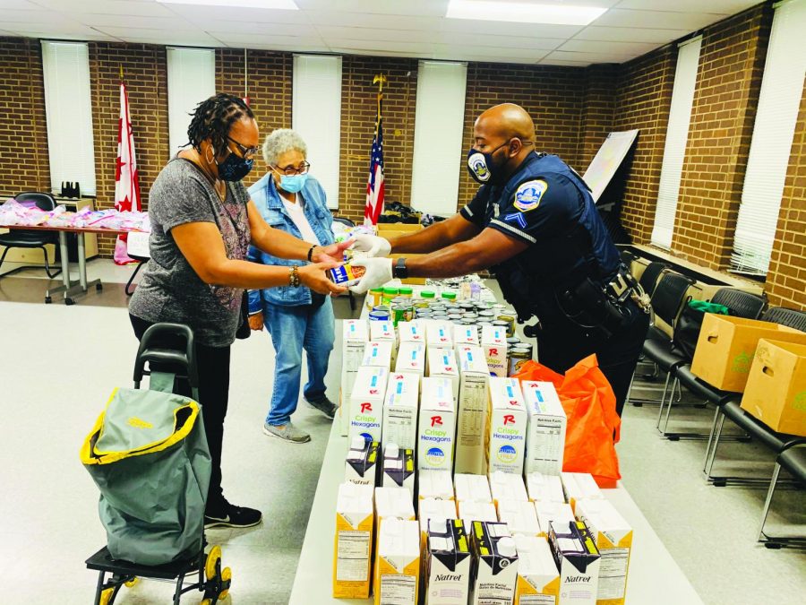 Perry Morgan, Jr. passes out food items to people in the Washington D. C. area who have come to the food bank for necessities.  Morgan said that he chooses to educate the communities that he patrols rather than to charge them. He hears them out, learns their stories, acknowledges their needs and courteously lets the public know that the Metro Police Department is not against them as people.