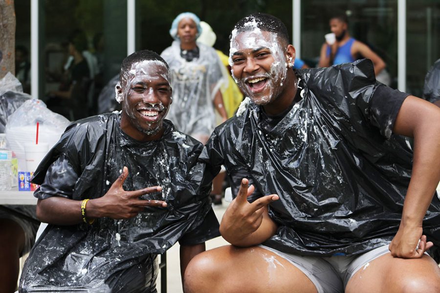 Jeremi Moore and Trint Martinez share a laugh after each of them were pied by students during a Welcome Week activity