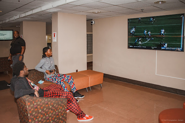 Students spend a number of hours in the lobbies of their residence halls either conversing with others or just relaxing from classes. Pictured are two residents watching an NFL football game.