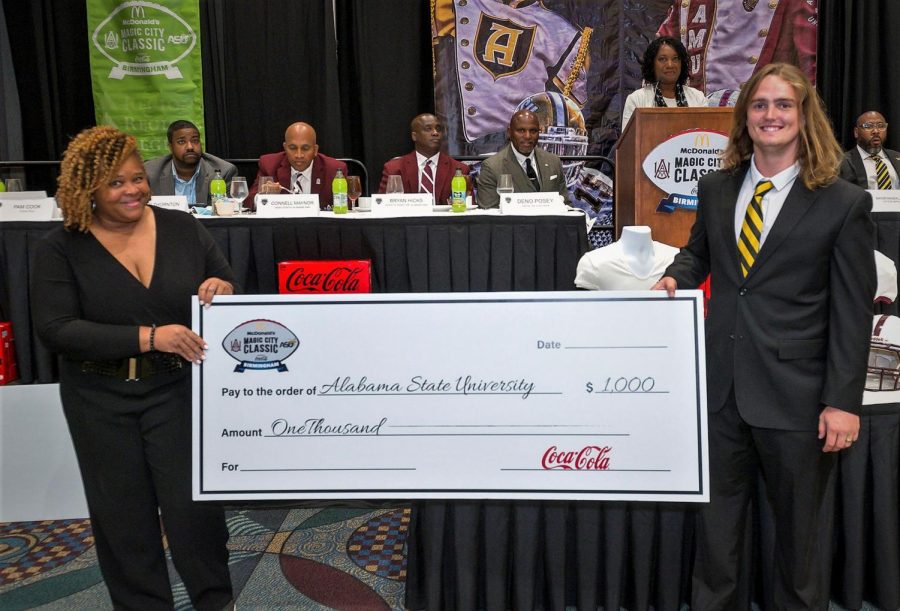 Pam Cook, Director of Multicultural Marketing and Community Affairs at Coca-Cola Bottling Company United, presents Alabama State University graduate student and long snapper Luke Barnes with a one thousand dollar scholarship for his academic achievements.