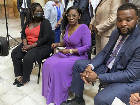 Relatives of Ahmaud Arbery including sister Jasmine Arbery, left, and mother Wanda Cooper Jones, second from left, sit at the Georgia state capitol in Atlanta on Monday, May 10, 2021. They witnessed Georgia Gov. Brian Kemp sign a law repealing citizen's arrest in Georgia, partly blamed for Ahmaud Arbery's fatal shooting death near Brunswick in 2020. (AP Photo/Jeff Amy)