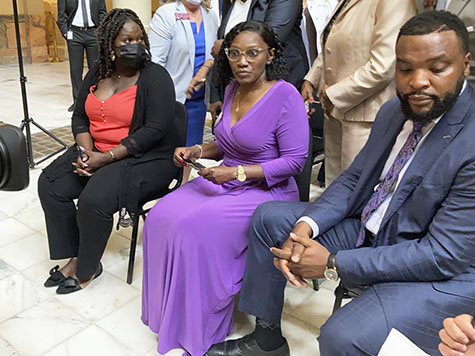 Relatives of Ahmaud Arbery including sister Jasmine Arbery, left, and mother Wanda Cooper Jones, second from left, sit at the Georgia state capitol in Atlanta on Monday, May 10, 2021. They witnessed Georgia Gov. Brian Kemp sign a law repealing citizen's arrest in Georgia, partly blamed for Ahmaud Arbery's fatal shooting death near Brunswick in 2020. (AP Photo/Jeff Amy)