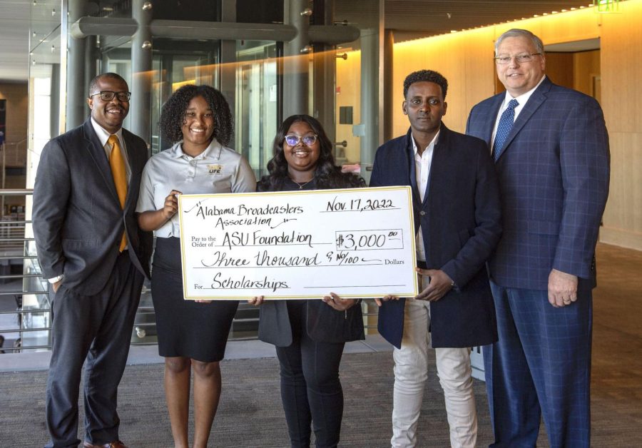 (L-R) Instructor Eric Knox, seniors Amayah Williams, Miracle Mims and Azigza Hussen, and Vice President and General Manager of WSFA-TV Mark Bunting pose for the university photographer as they hold the check that was awarded to the scholarship winners in the amount of $3,000. 