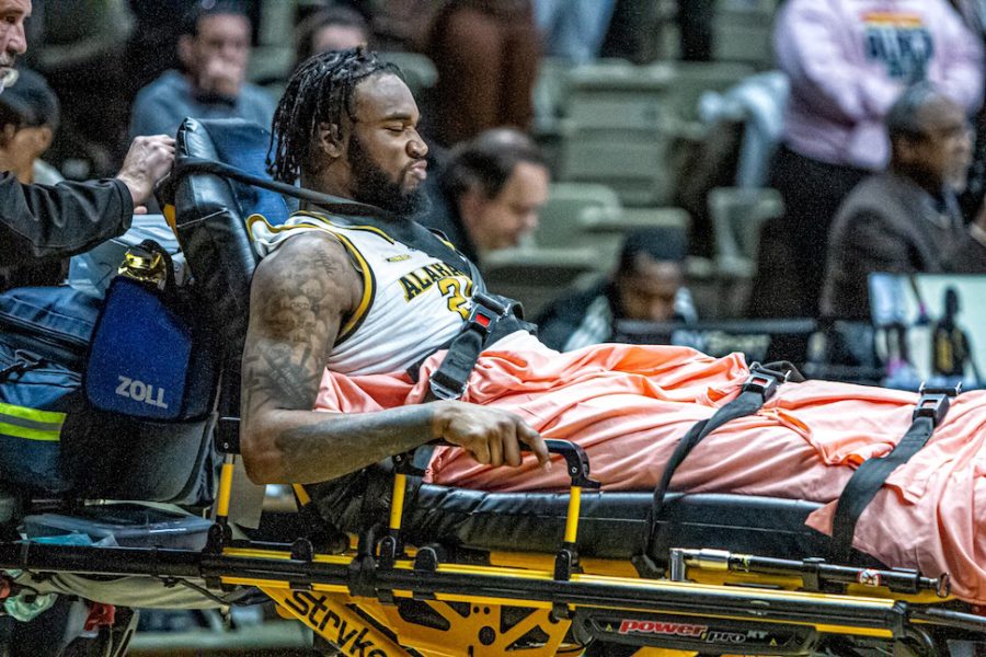 Paramedics placed Isaiah Range on the gurnee as they rush him to the hospital after his injury on the Dunn-Oliver Acadome.