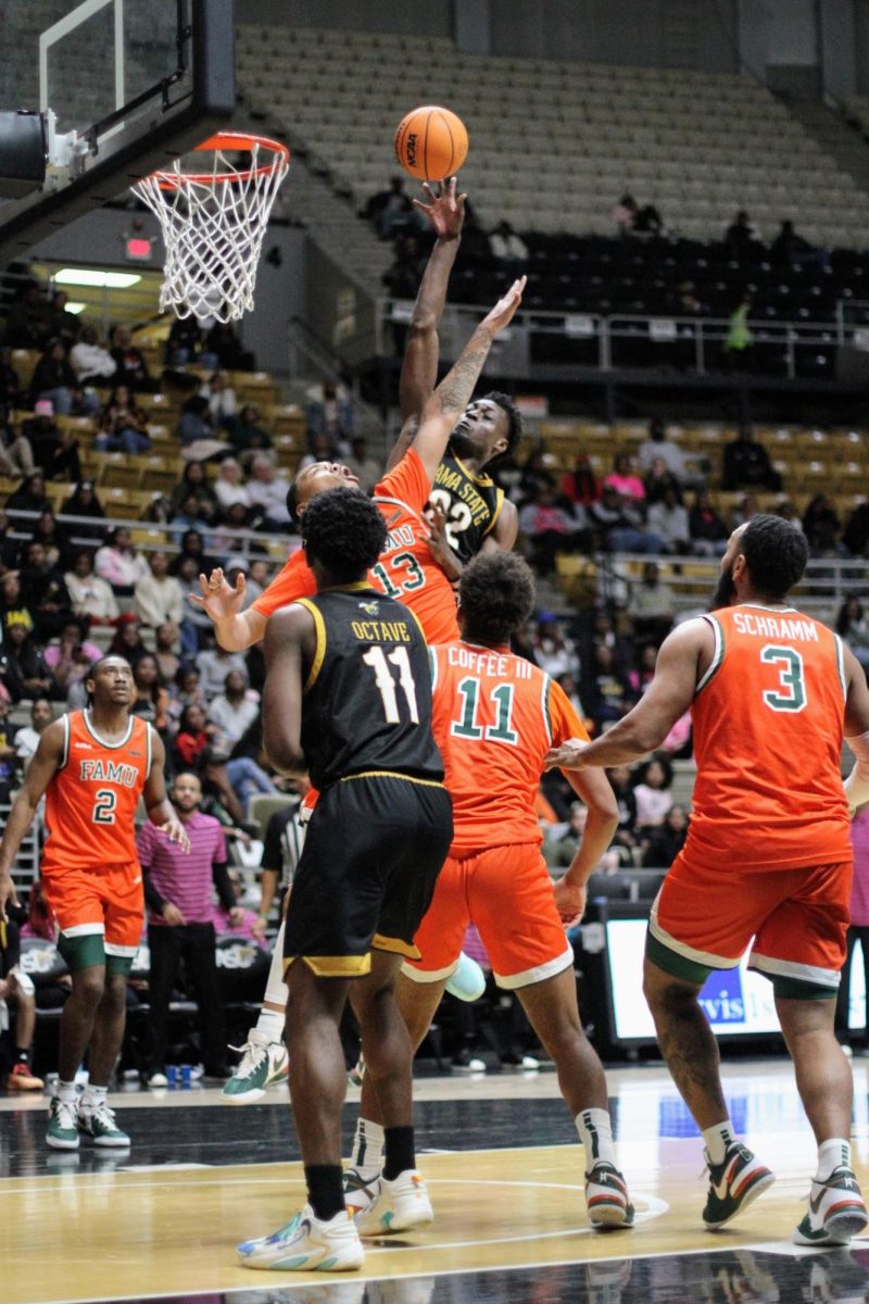 Alabama State University Hornets forward Darrell Reed (#22) attempts to put a missed shot back in the basket while fending off Florida Agricultural and Mechanical University Rattlers Shannon Grant (#13).  The Hornets out rebounded the Rattlers 46 to 38.