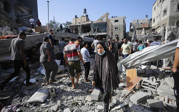 Palestinian people look for belongings as well as victims as they search the rubble after air strikes hit Gaza.
