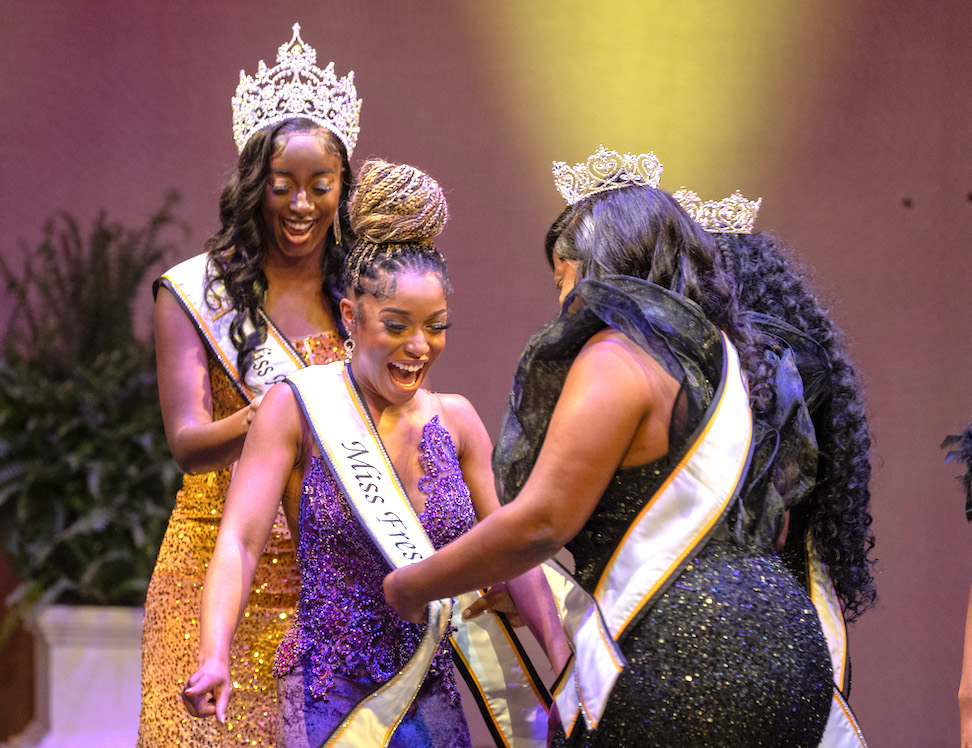 Mariama Rogers (center) is assisted with her regalia by Aarin Carver, Miss ASU (left) and Faith Blackwell, Miss Senior (right).