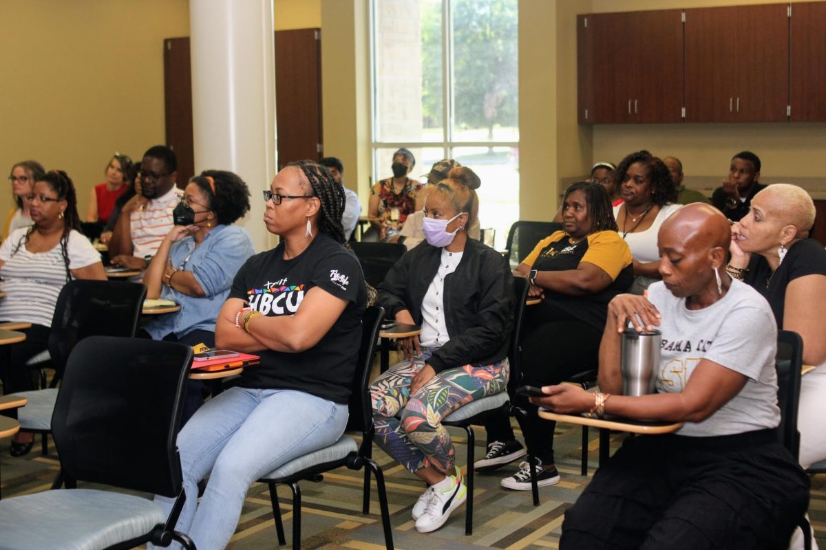 Members of the faculty and staff listen carefully as the presenters demonstrate the power of artificial intelligence.