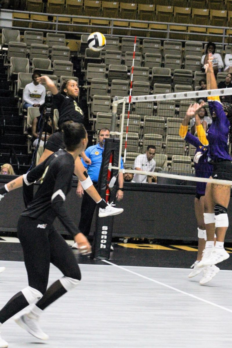 Alabama State University Hornets middle hitter Kaylen Hines leaps up to spike the ball against the Prairie View Agricultural and Mechanical University Panthers on Sept. 7 at the Dunn-Oliver Acadome.