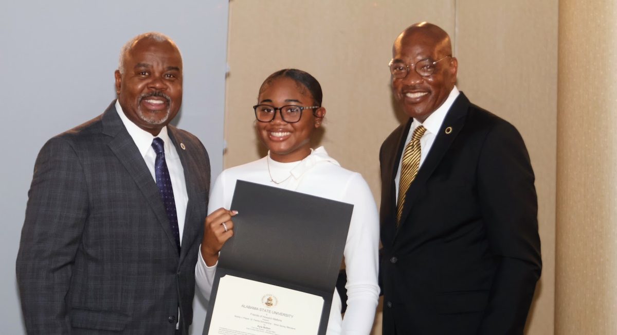 President Quinton T. Ross Jr., Kyla Bolton and scholarship donor Howard Watkins take a minute to pose for the photographer as Bolton accepts her scholarship award.