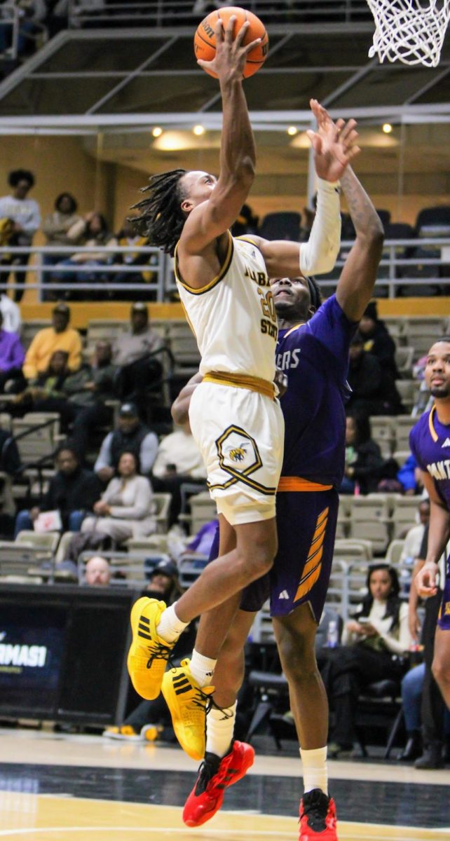 Left) Alabama State University Hornets star point guard TJ Madlock attempts a layup at the rim a a Prairie View Agricultural and Mechanical University Panther defends his layup, but lands on his hip instead.