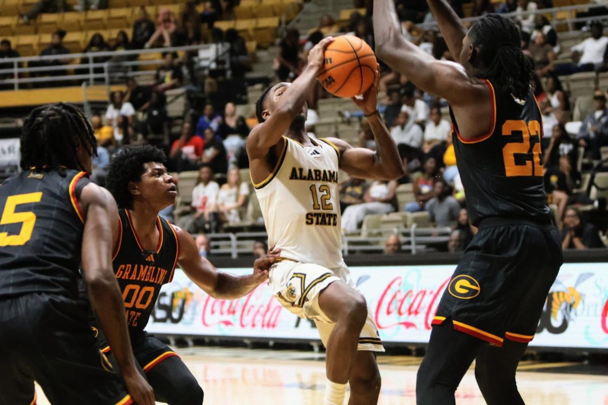 Alabama State University Hornets guard Shawn Fulcer attempts a hook shot in the paint while being contested by Grambling State University Tigers forward Emeka Nnaji.